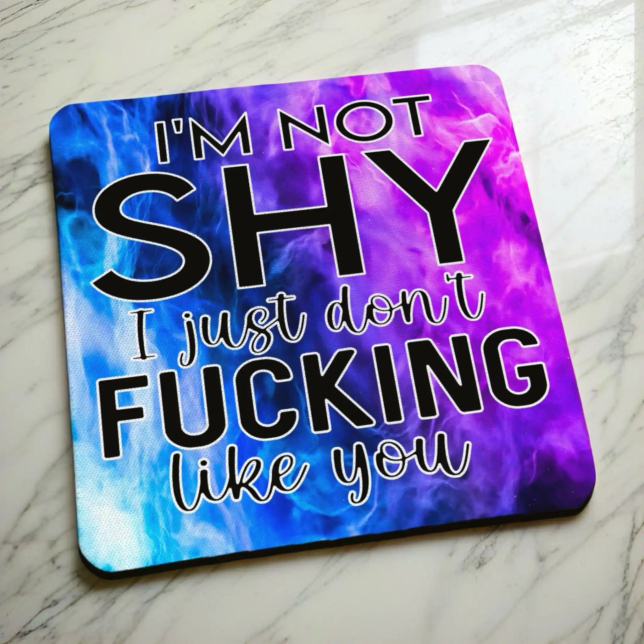 Side view of I'm Not Shy I Don't Like You neoprene coaster with a slim black rubber base beneath the vibrant purple watercolour nebula design, by Laser Design Creations.