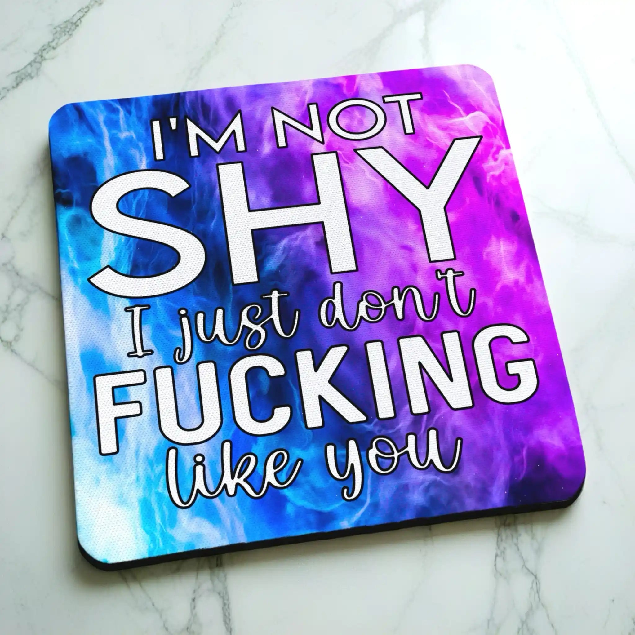 Side view of I'm Not Shy I Don't Like You neoprene coaster with a slim black rubber base beneath the vibrant purple watercolour nebula design, by Laser Design Creations.