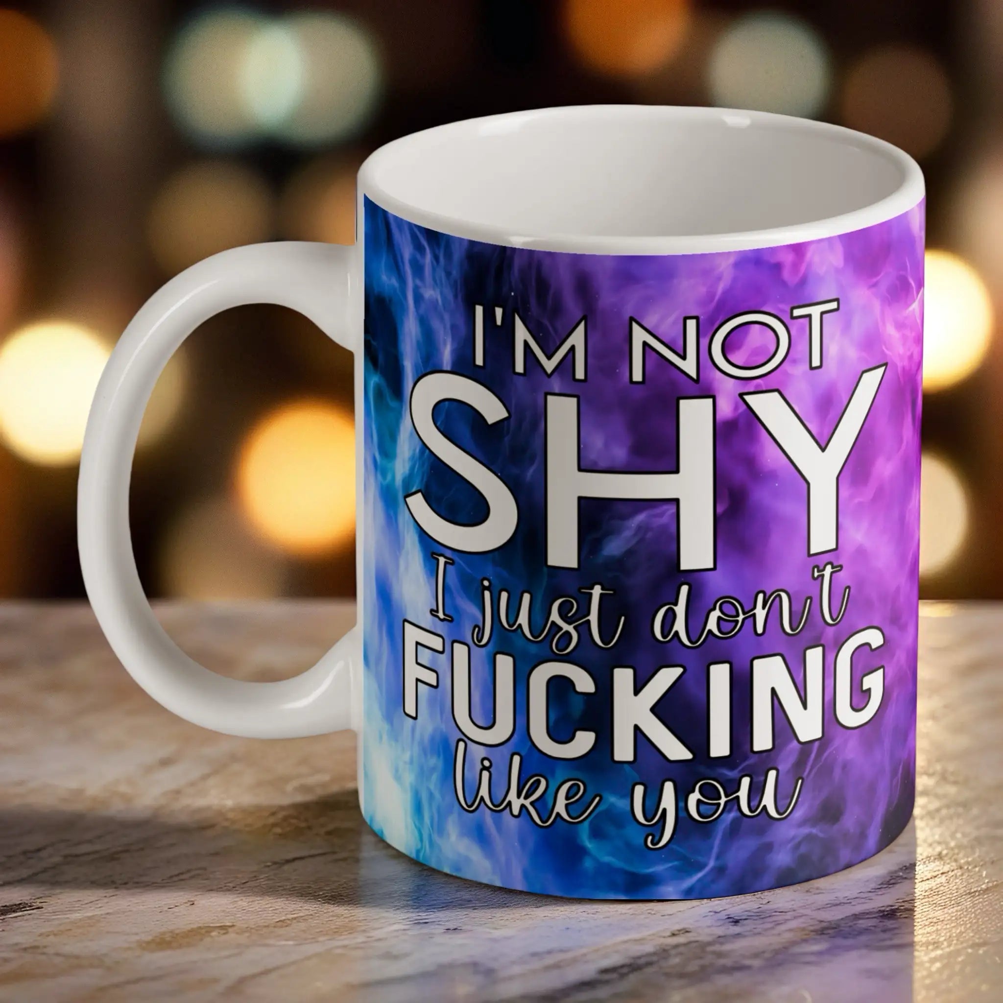 I'm Not Shy I Don't Like You ceramic mug by Laser Design Creations, featuring the humorous quote in bold typography set against a vibrant purple watercolour nebula smoke background.