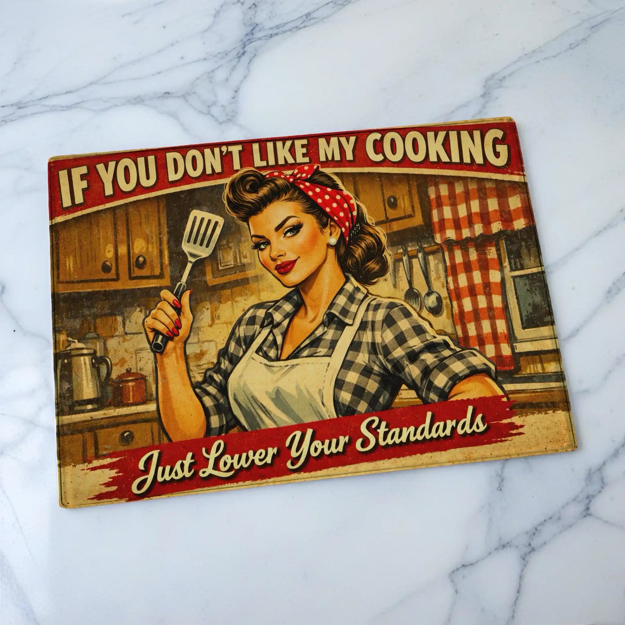 Humorous retro vintage style chopping board from Laser Design Creations featuring the phrase If You Don't Like My Cooking Just Lower Your Standards with pin-up artwork.