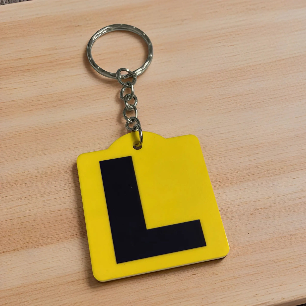 Side view of Learner L Plate acrylic keyring, showcasing an iconic Australian driving plate design against a soft neutral background by Laser Design Creations.