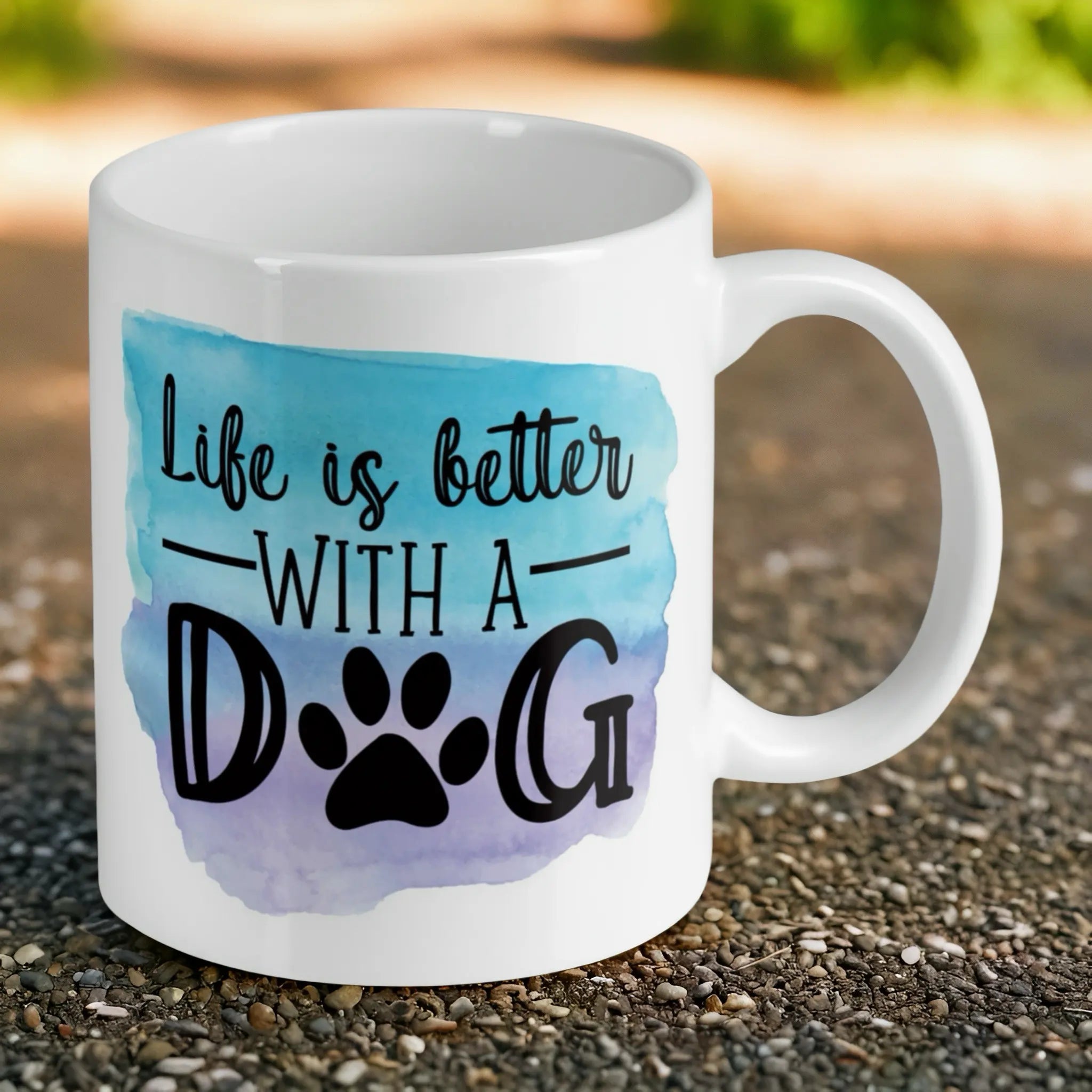 Reverse side of Life is better with a dog quote and watercolour paw print ceramic mug, showcasing the quote 'Life is better with a dog' in modern typography next to a colourful watercolour paw print on a white background by Laser Design Creations.