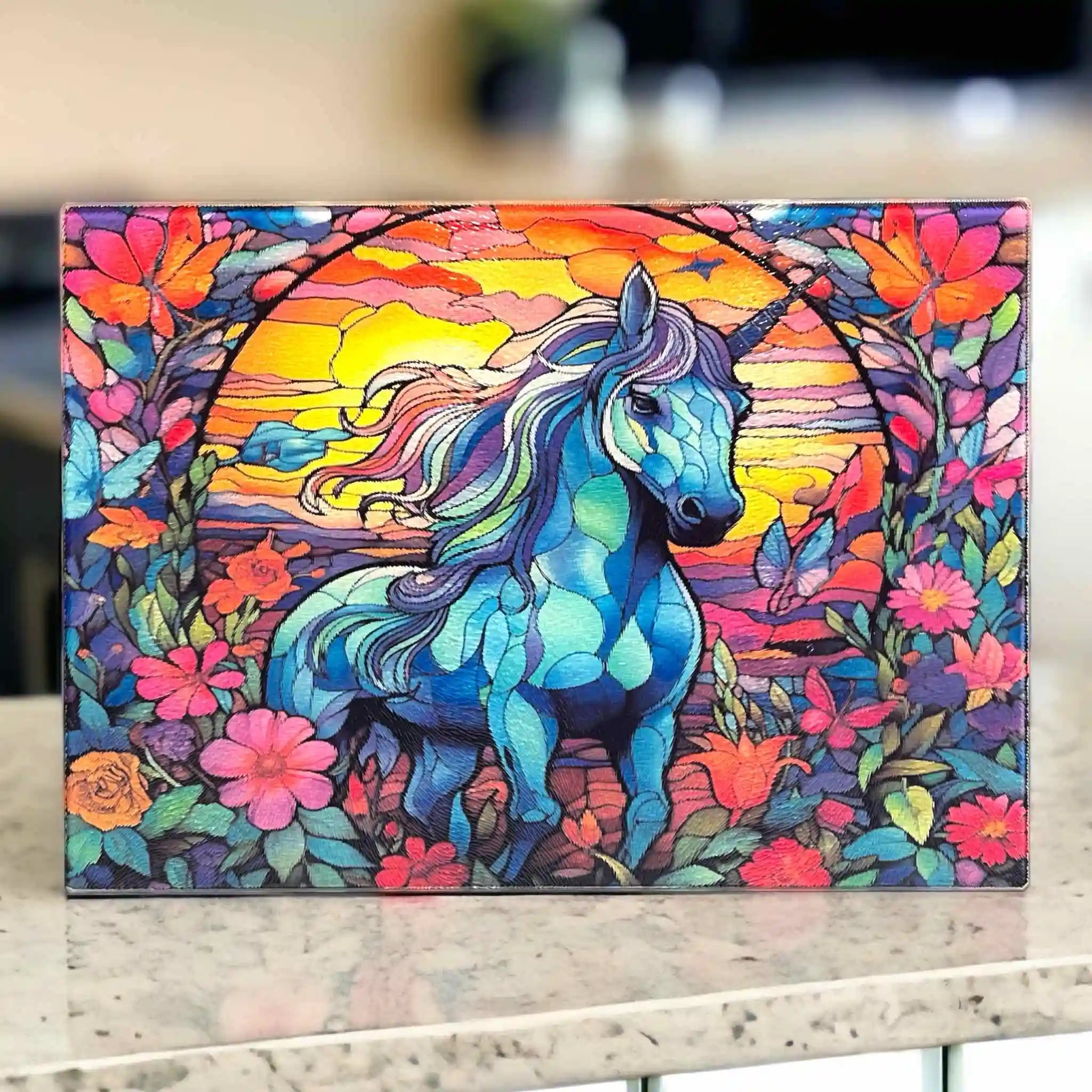A vibrant, artistic design of a unicorn in a stained-glass style, surrounded by colourful flowers, printed on a chopping board from Laser Design Creations