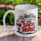 Funny Santa My Sack Is Huge 11oz ceramic mug by Laser Design Creations, featuring a crude humour cartoon Santa holding a massive toy sack, clearly displaying the text "My Sack Is Huge".