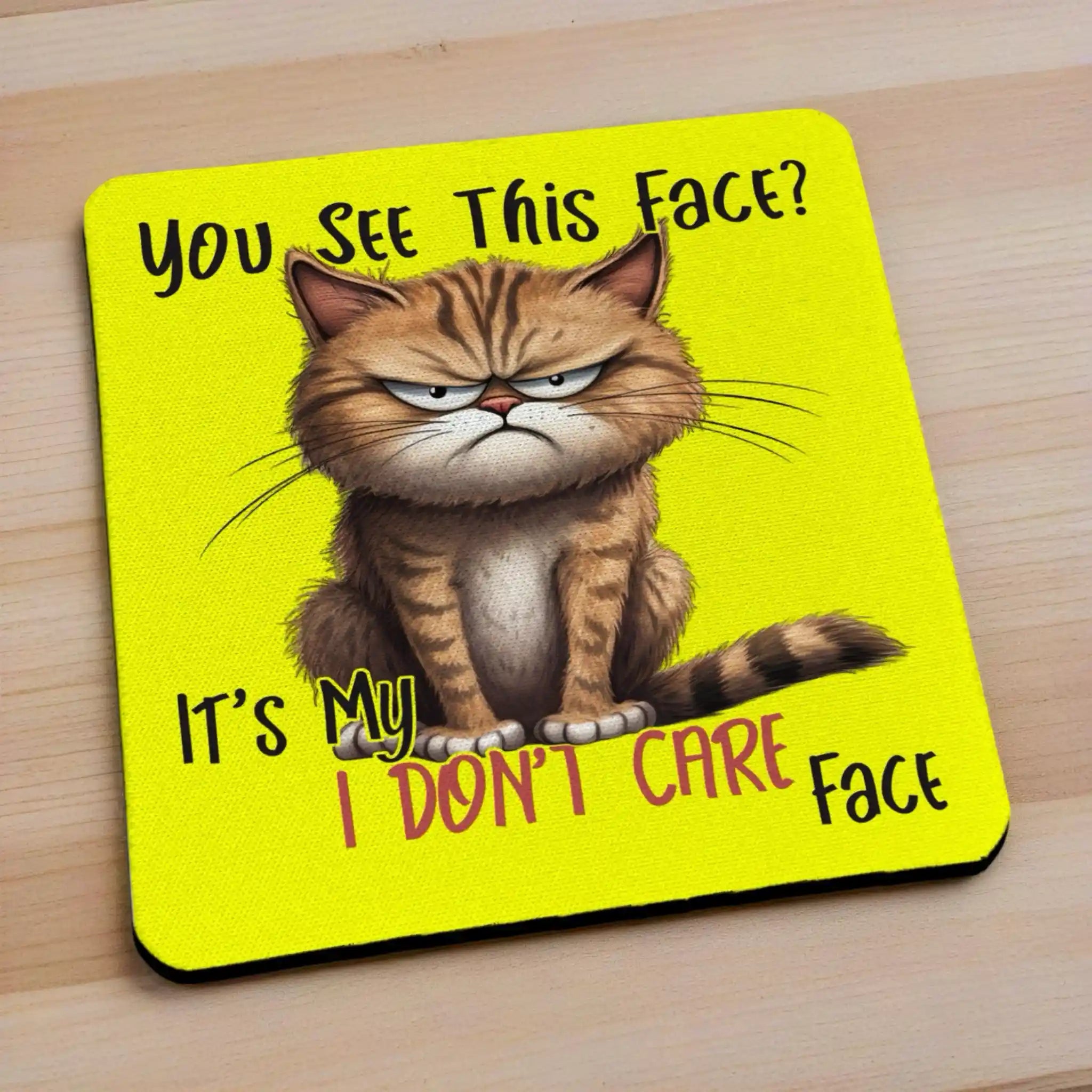 Side view of My I Don't Care Face Grumpy Yellow Cat neoprene coasters, showcasing a humorous cartoon grumpy yellow cat face with the quote, You See This Face? It's My I DON'T CARE Face on a vibrant background, by Laser Design Creations.