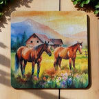 Top view of a set of four Peaceful Horses neoprene coasters with a rustic farm scene and warm sunset, by Laser Design Creations.