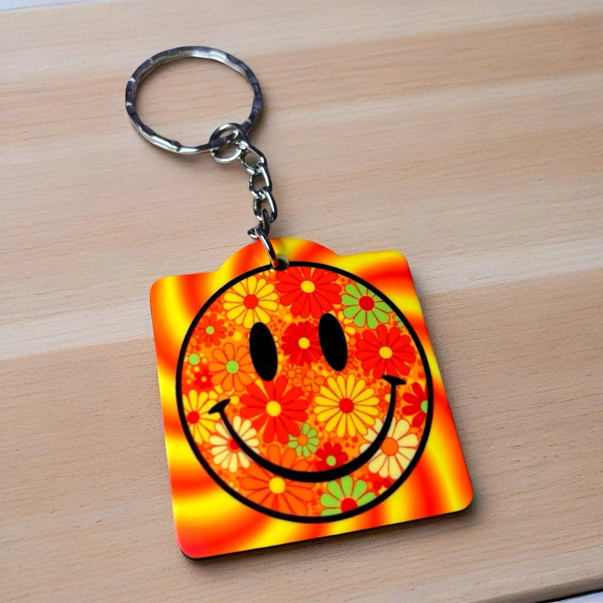 Psychedelic Floral Smiley Face keyring, showcasing a vibrant yellow smiley face and groovy floral patterns by Laser Design Creations.