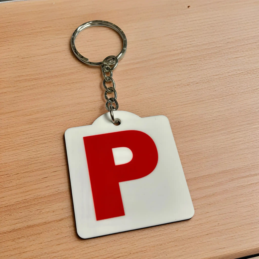 Side view of Red P Provisional Plate acrylic keyring, showcasing an iconic Australian driving plate design against a soft neutral background by Laser Design Creations.