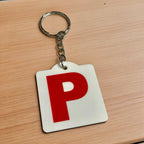 Side view of Red P Provisional Plate acrylic keyring, showcasing an iconic Australian driving plate design against a soft neutral background by Laser Design Creations.