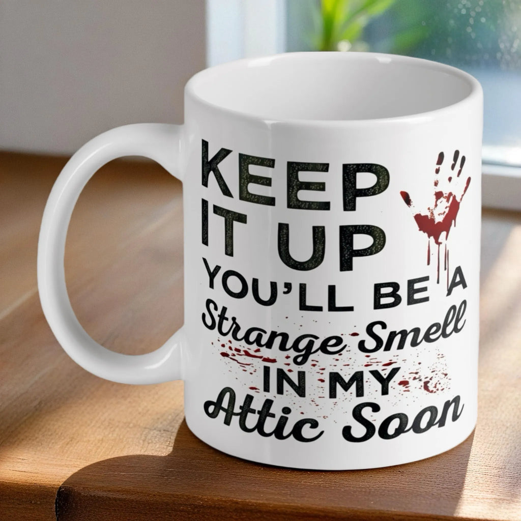 Funny 'Strange Smell In My Attic' quote ceramic mug by Laser Design Creations, featuring a sarcastic dark humour quote with a bloody handprint.