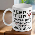 Funny 'Strange Smell In My Attic' quote ceramic mug by Laser Design Creations, featuring a sarcastic dark humour quote with a bloody handprint.