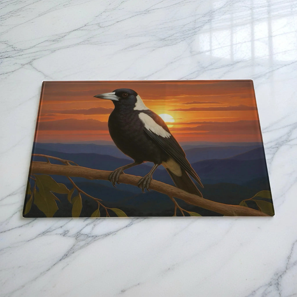 Sunset magpie on branch chopping board by Laser Design Creations, featuring a native Australian bird perched on a tree branch with a scenic mountain sunset in the background.