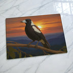 Scenic sunset mountain range with an Australian magpie chopping board from Laser Design Creations featuring a realistic native bird perched on a branch against a glowing sunset.
