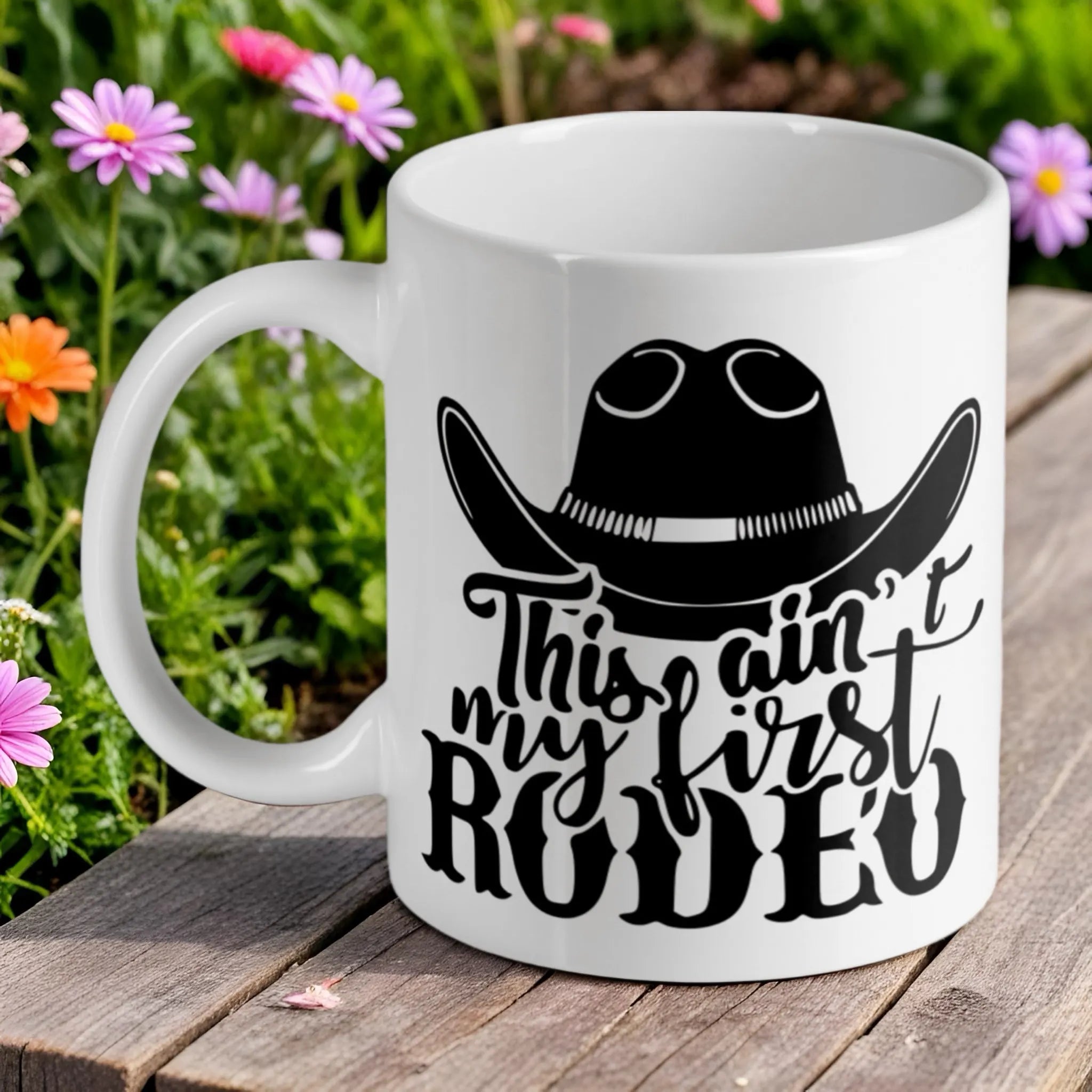 "This ain't my first rodeo" ceramic mug by Laser Design Creations, featuring a funny quote and a cowboy hat.