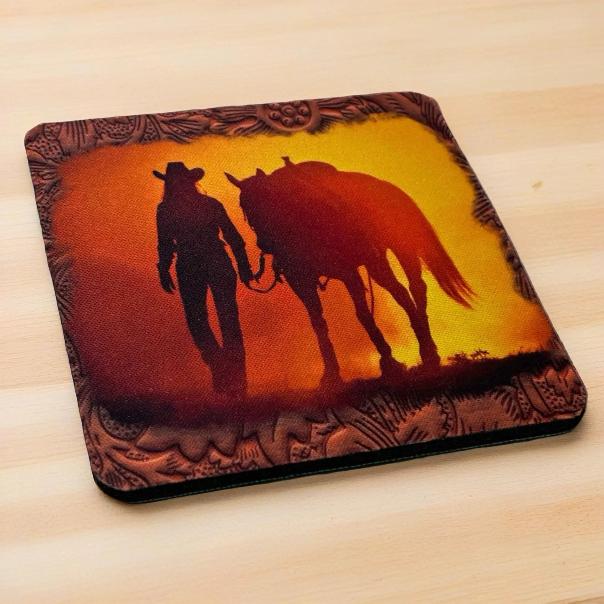 Side view of a set of four Western Cowgirl Sunset neoprene coasters with a rustic embossed-style frame, by Laser Design Creations.
