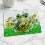 Cute Frog Daisy Sunflower glass chopping board by Laser Design Creations, featuring a happy green frog surrounded by bright yellow sunflowers and white daisies. Displayed on a marble countertop.