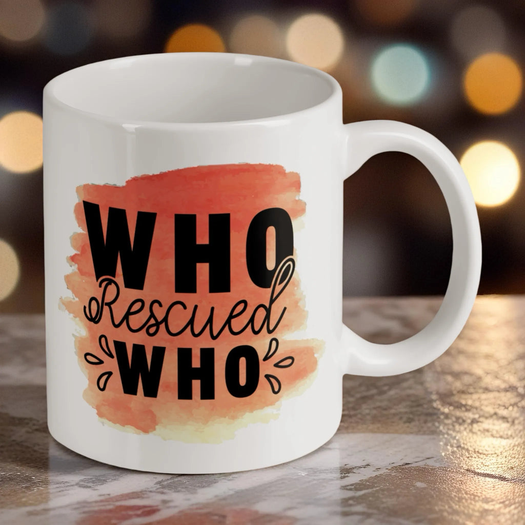 Reverse side of 'Who Rescued Who' Quote ceramic mug, showcasing the heartfelt message in black typography over a soft peach watercolour splotch by Laser Design Creations.