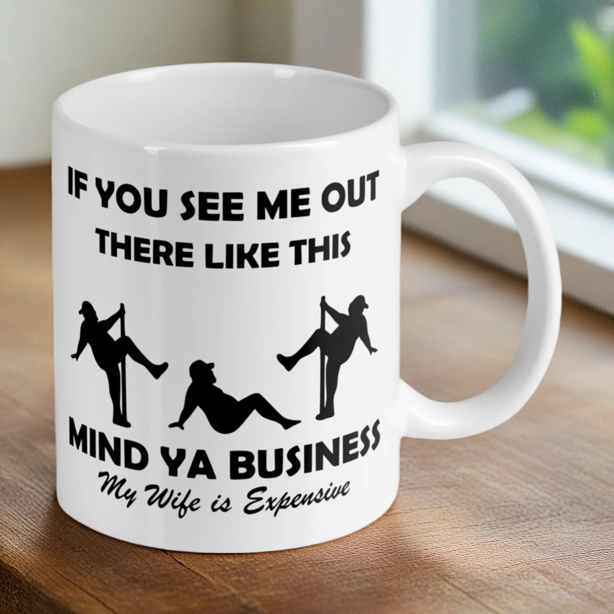Lifestyle image of the 'My Wife is Expensive' coffee mugs on a desk, printed by Australian small business Laser Design Creations.