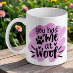 'You Had Me At Woof' ceramic mug by Laser Design Creations, featuring a funny dog quote with a paw print detail against a soft purple watercolour background.