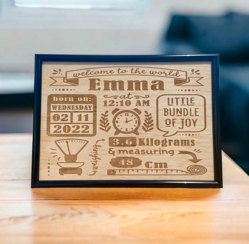 A personalized wooden plaque with engraved baby name birth details, displayed on a table.